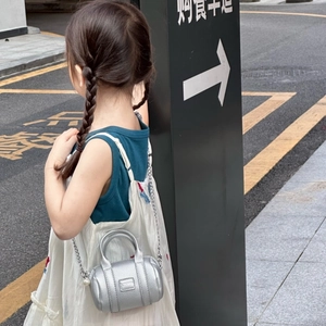 Detailed view of silver mini cylinder bag for kids with pearl chain strap and leather texture