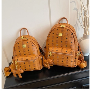 Detail view of brown bear print backpacks with gold zippers and metal stud accents