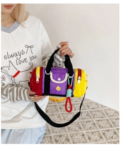 Detail of colorful cylinder shoulder bag for kids with patchwork design and crossbody strap
