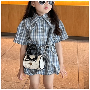 Détail du mini sac cylindre pour enfant avec nœud papillon et breloque cœur sur modèle