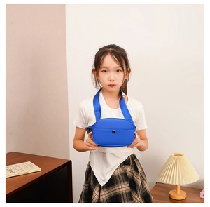 Close-up of a blue nylon kids fanny pack with adjustable strap worn by a young girl