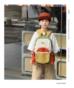 Close-up of stylish color-block kids backpack with olive green and orange contrast detail