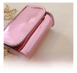 Detailed close-up of pink laser glossy crossbody bag with fine stitching and gold chain