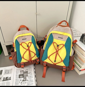Comparación de mochilas de exterior en beige, amarillo y cian con diseño de bloques de color