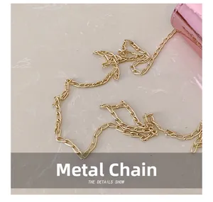 Detailed macro shot of the golden metal chain hardware and pink leather material