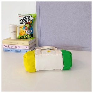 Detail of color-block cylinder bag with duck embroidery and durable cream handles