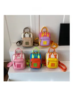 Vista piatta di mini zaini in tela per bambini con design colorati a contrasto vivace