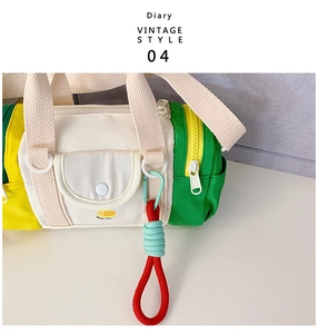 Detail of colorful cylindrical canvas bag with duck print and green woven handle