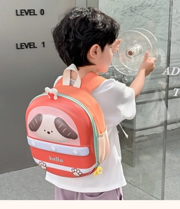 Side view of red and orange cartoon eggshell backpack featuring 3D dog and mesh pocket