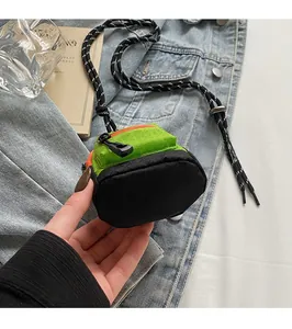 Détail du mini sac vert néon et noir avec cordon tressé et texture grillagée détaillée