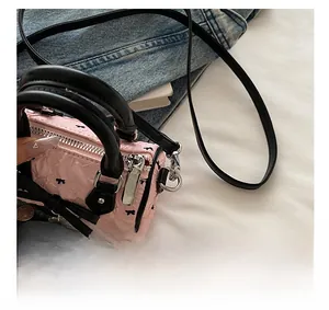 Détail du zip argenté et texture plissée rose sur un mini sac tonneau à nœuds