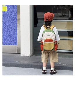 Outdoor view of child wearing colorful large capacity school backpack on urban street
