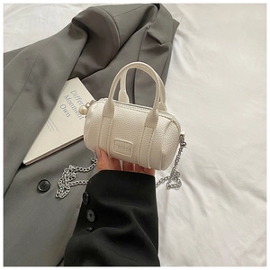 Mini cream barrel bag featuring lychee texture with pearl charm and silver chain strap