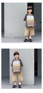 Detail of a color-block kids backpack with multiple compartments and adjustable buckles