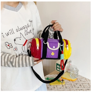 Detail of color-block cylinder bag with cute duck embroidery and black strap