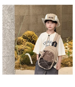 Outdoor close-up of earth-tone nylon chest bag with zipper and elastic drawstring detail