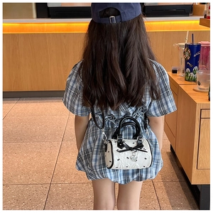 Sac à main pour petite fille avec imprimé nœuds noirs et pendentif cœur en situation