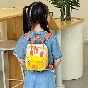 Mini zaino per bambini in tela color-block giallo e arancione indossato da bimbo