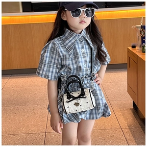 Détail d'un mini sac à main Boston blanc avec un nœud noir et un pendentif en cœur