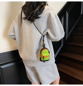 Détail du mini porte-monnaie en maille vert néon avec zip orange et cordon tressé