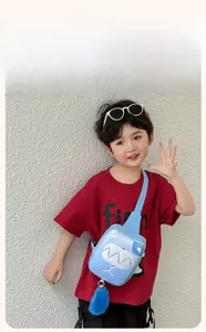 Detail of light blue kids chest bag with cartoon teeth pattern and fluffy fur tail charm