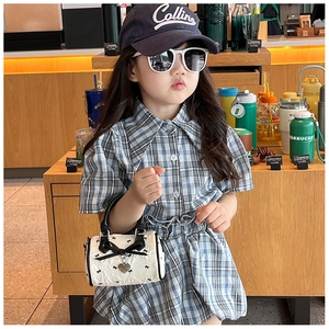 Gros plan d'un mini sac à main blanc pour filles avec imprimés nœuds noirs et pendentif cœur