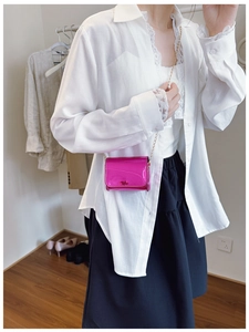 Mini metallic magenta chain crossbody bag shown on a model for scale and fit