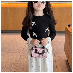 Détail du mini sac baril rose gaufré avec nœud et breloque cœur pour petites filles