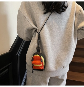 Gros plan d'un mini porte-monnaie à carreaux orange avec fermeture éclair jaune fluo
