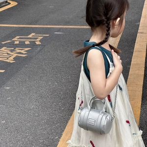 Girl's silver cylinder crossbody bag with chain strap and pearl charm accessory