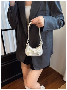 Close-up of kids white laser mirror handbag with sweet bow tie decoration and top handle
