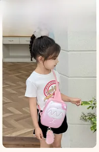 Close-up of pink cartoon kids chest bag with white monster face and plush pompom charm