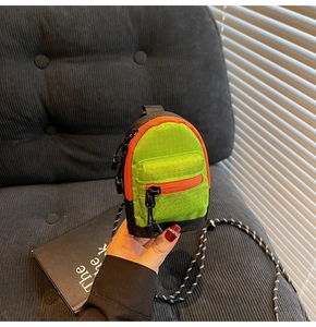 Détail du mini porte-monnaie contrasté aux tons vert orange et sangle tissée