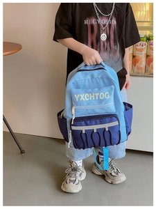 Handheld view of blue contrast backpack featuring reflective strips and letter print