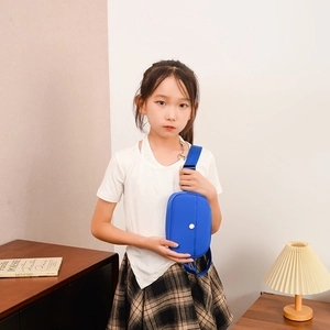 Bright blue children's mini crossbody chest bag with adjustable strap worn by a girl