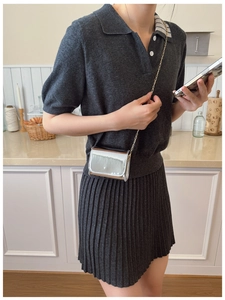 Silver laser metallic crossbody bag for kids with gold chain strap in a kitchen setting