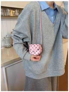 Detail view of pink polka dot mini crossbody bag with heart decoration for girls