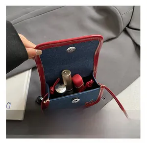 Detailed interior of mini crossbody bag showing cherry embroidery and magnetic clasp