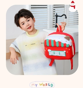 Detail view of red house-shaped kids backpack with candy shop design and white snow roof