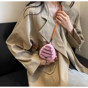 Close-up of pink mesh triangle crossbody bag with orange lanyard on model