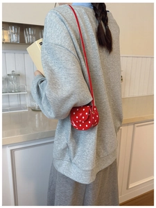 Polka dot heart crossbody bag for kids shown being worn for size and scale