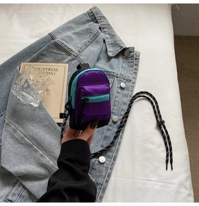 Détail du mini porte-monnaie en nylon violet et bleu avec cordon réglable et fermeture éclair