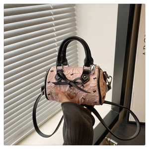 Détail du mini sac Boston plissé rose avec imprimés nœuds et pendentif coeur
