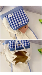 Detail view of canvas drawstring backpack with blue plaid pocket and internal zipper bag