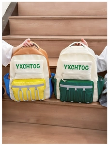 Close-up of contrast color school backpacks with reflective strips and drawstring details
