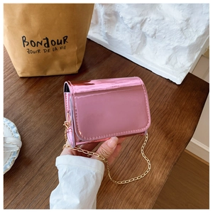 Close-up of a mini metallic pink chain bag with a glossy mirror finish for girls