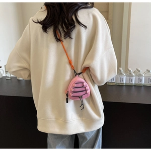 Detail of pink mesh mini crossbody bag for kids with orange woven strap and drawstring