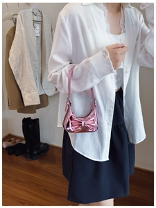 Metallic pink kids handbag with oversized bow detail and glossy reflective finish