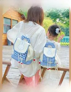 Outdoor view of matching blue plaid rabbit backpacks for parent and child