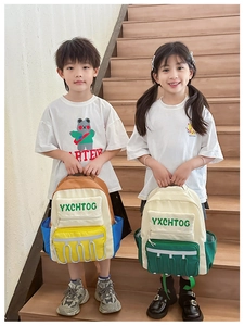 Detail of color-block kids backpack with reflective strips and side mesh pockets